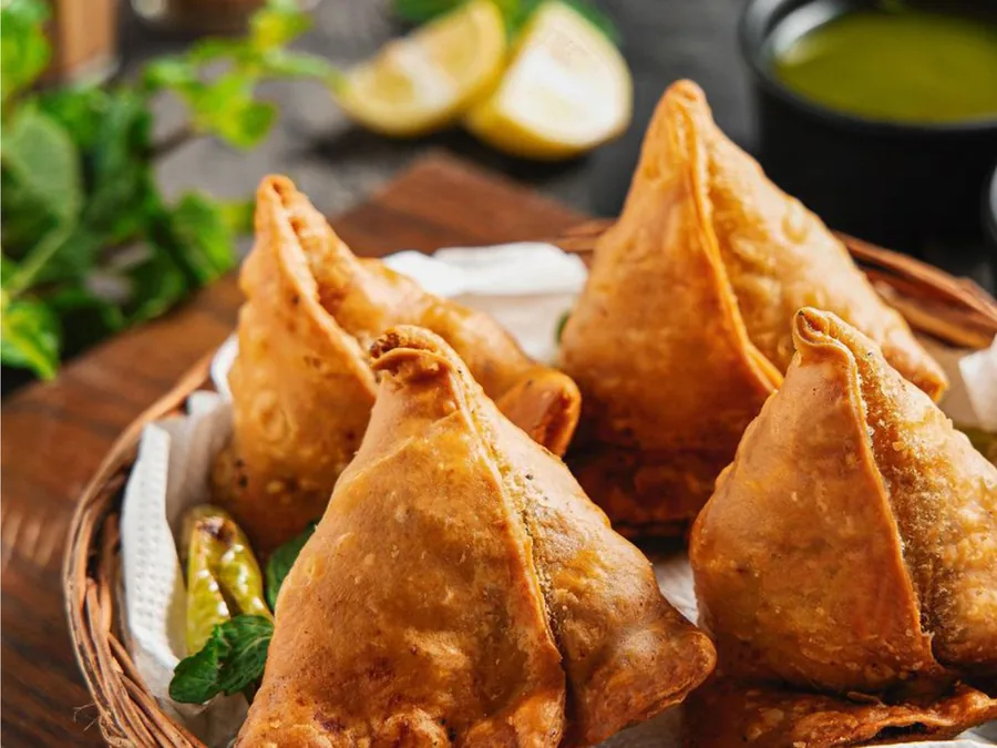 Crisp samosas served with chutney, part of the frozen snack range